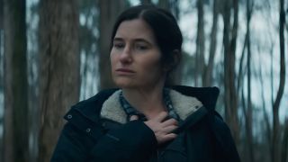 Kathryn Hahn as Agatha standing in a foreset with her hand on her chest.