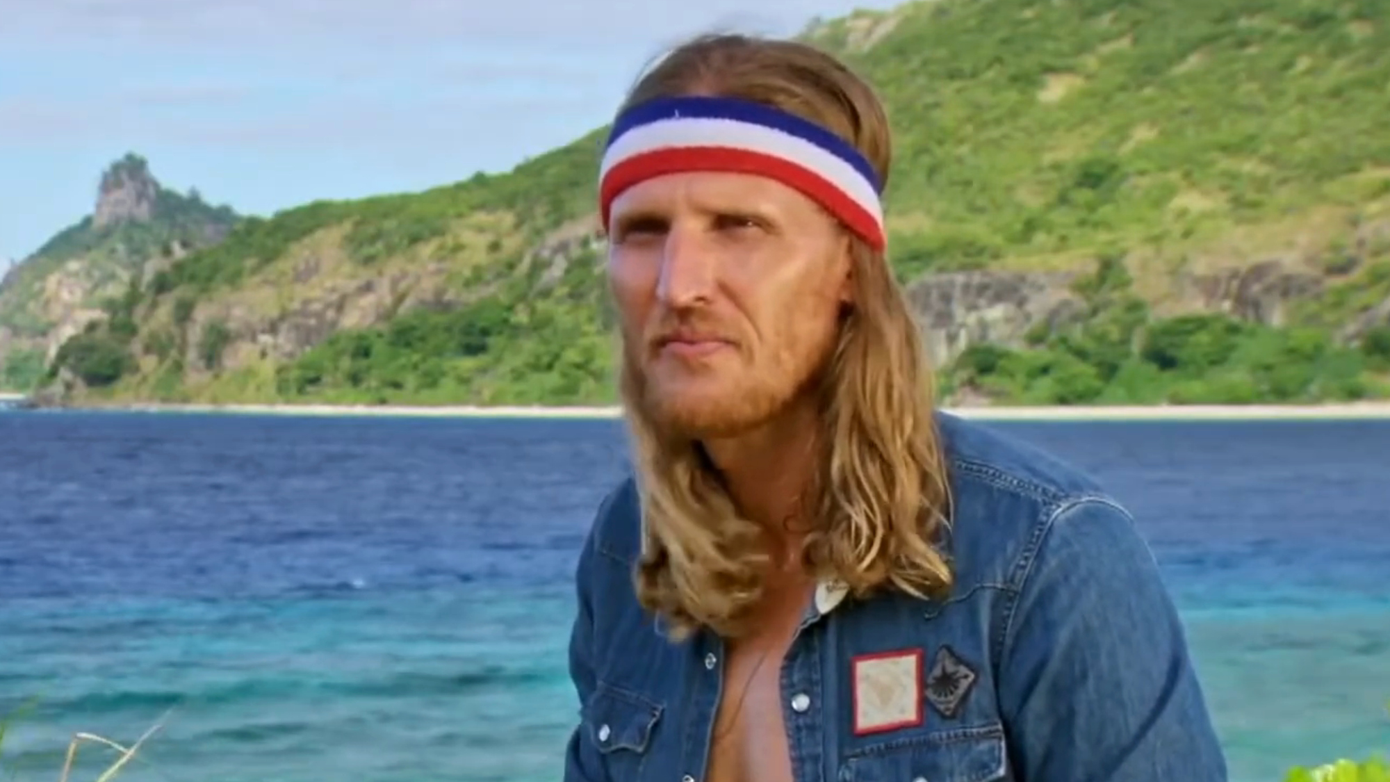 Tyson wears a red, white and blue headband and talks during a confessional on Survivor.