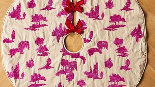 A tan tree skirt with pink embroidered designs and red bows