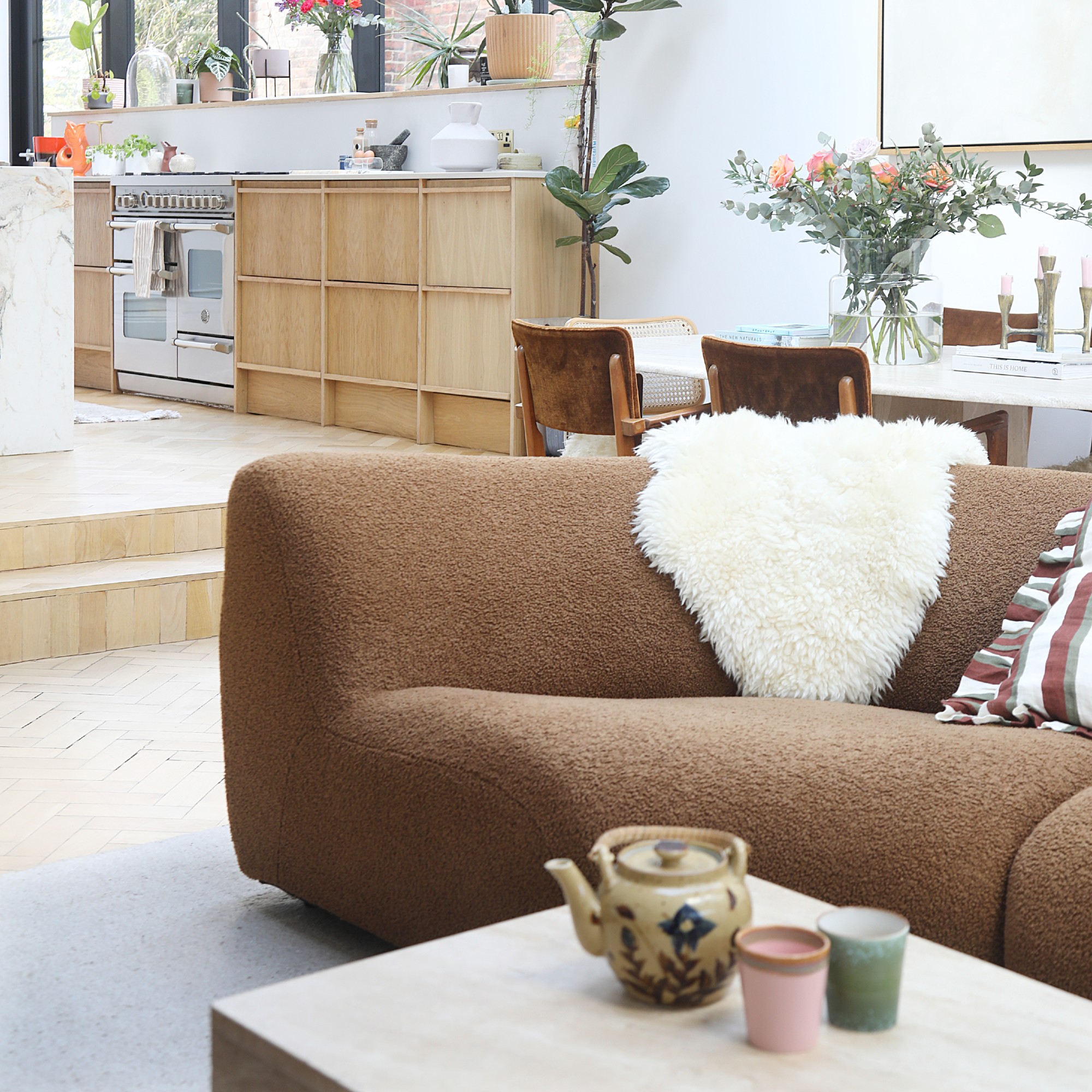 An open-plan living room with a modular King Living 1977 sofa in brown covers