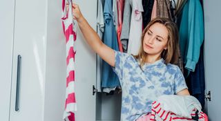 Woman deciding which clothes to keep