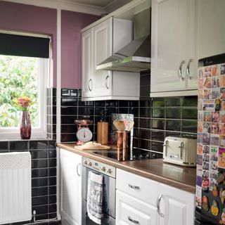 kitchen with black tiles on wall and chimney