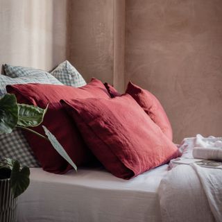 Crimson red pillows on white and grey bed