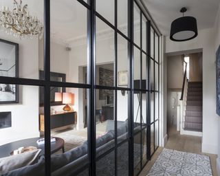 A modern hallway idea with crittall wall dividing it from the living room