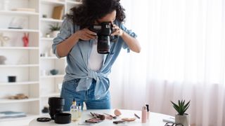Professional Photographer Lady using camera for flat lay shot of cosmetics