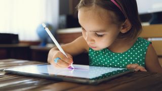The best drawing tablets for kids as represented by a photo of a girl drawing