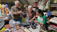 Three members of the Forest Fixers repair cafe attempting to repair a Soundcraft mixer.