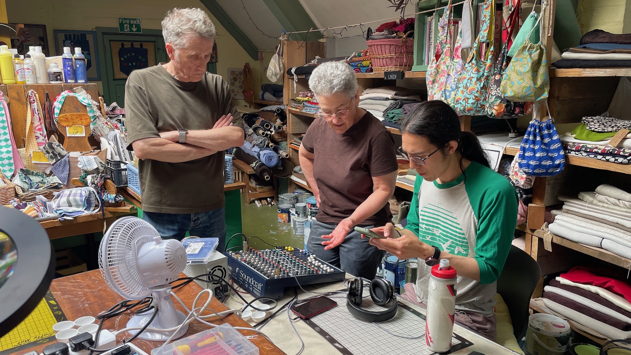 Three members of the Forest Fixers repair cafe attempting to repair a Soundcraft mixer.