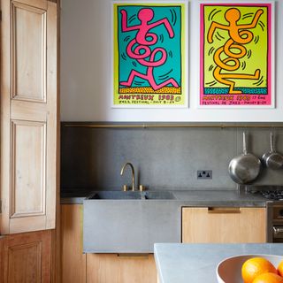 modern kitchen with wooden units, slate style worktop, sink and splash back, bold pop art style artwork