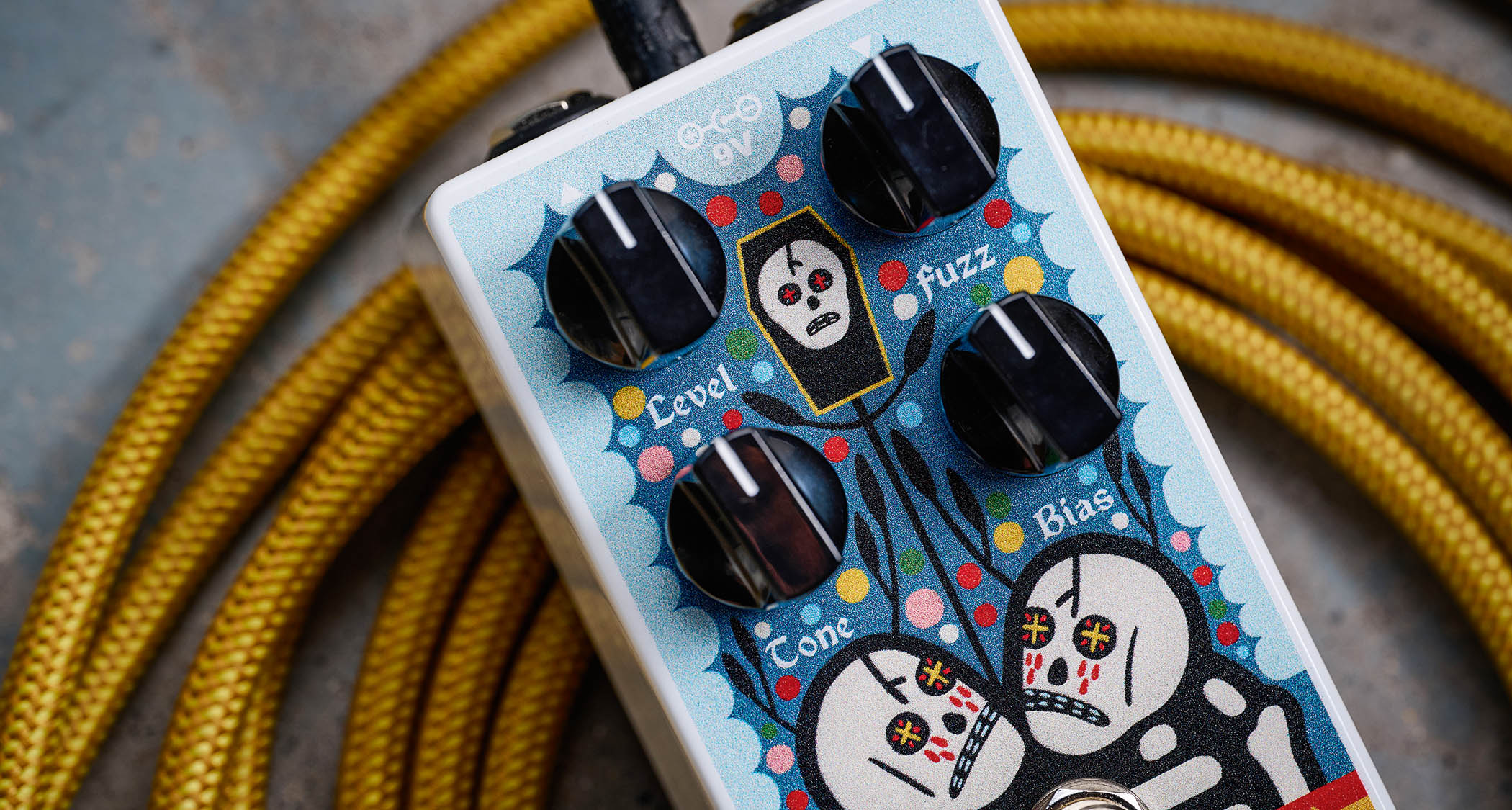 EarthQuaker Devices Rancho de la Luna Dirt Transmitter Fuzz Driver photographed on top of a tweed yellow guitar cable.