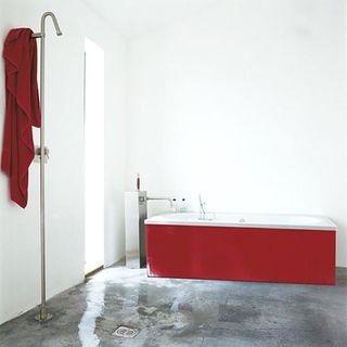 bathroom with red bathtub and towel