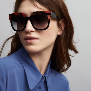 Model wearing black wide frame sunglasses