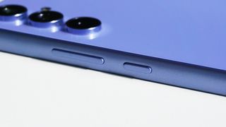 Sidoknapparna på en lila Samsung Galaxy A54 som ligger med baksidan vänd uppåt.