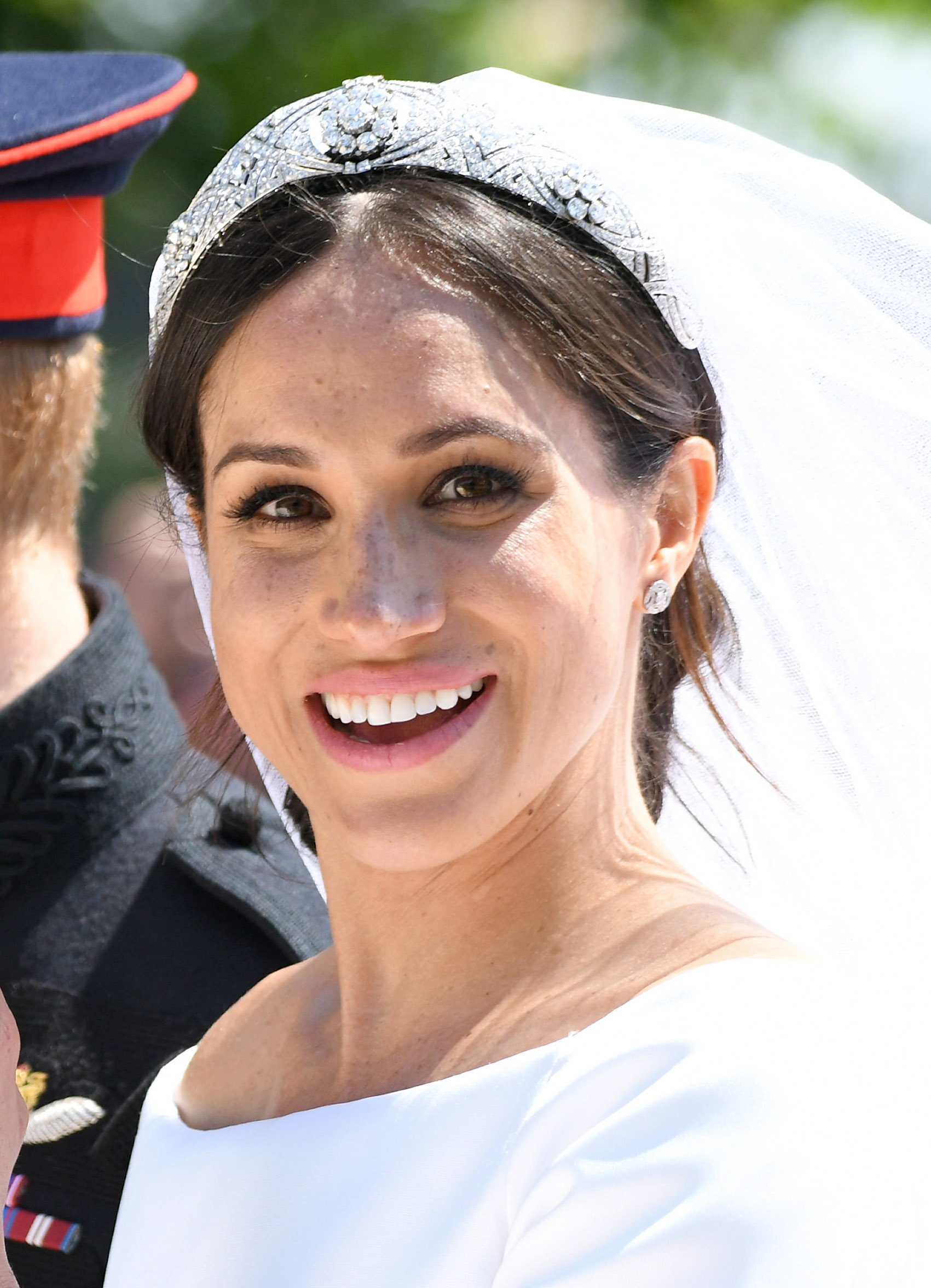 Meghan Markle in a carriage on her wedding day wearing a white dress and veil with a tiara