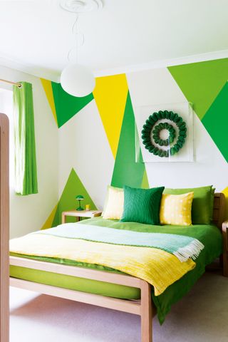 A bedroom decorated in green and yellow geometric pattern