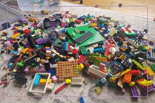 A pile of LEGO bricks on a carpet
