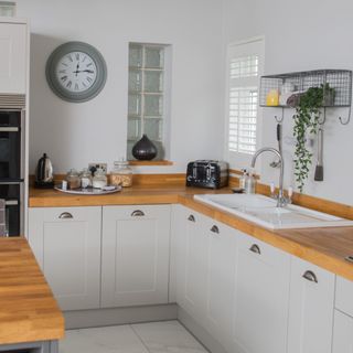 kitchen with white cabinets, wooden countertops, sink and black toaster