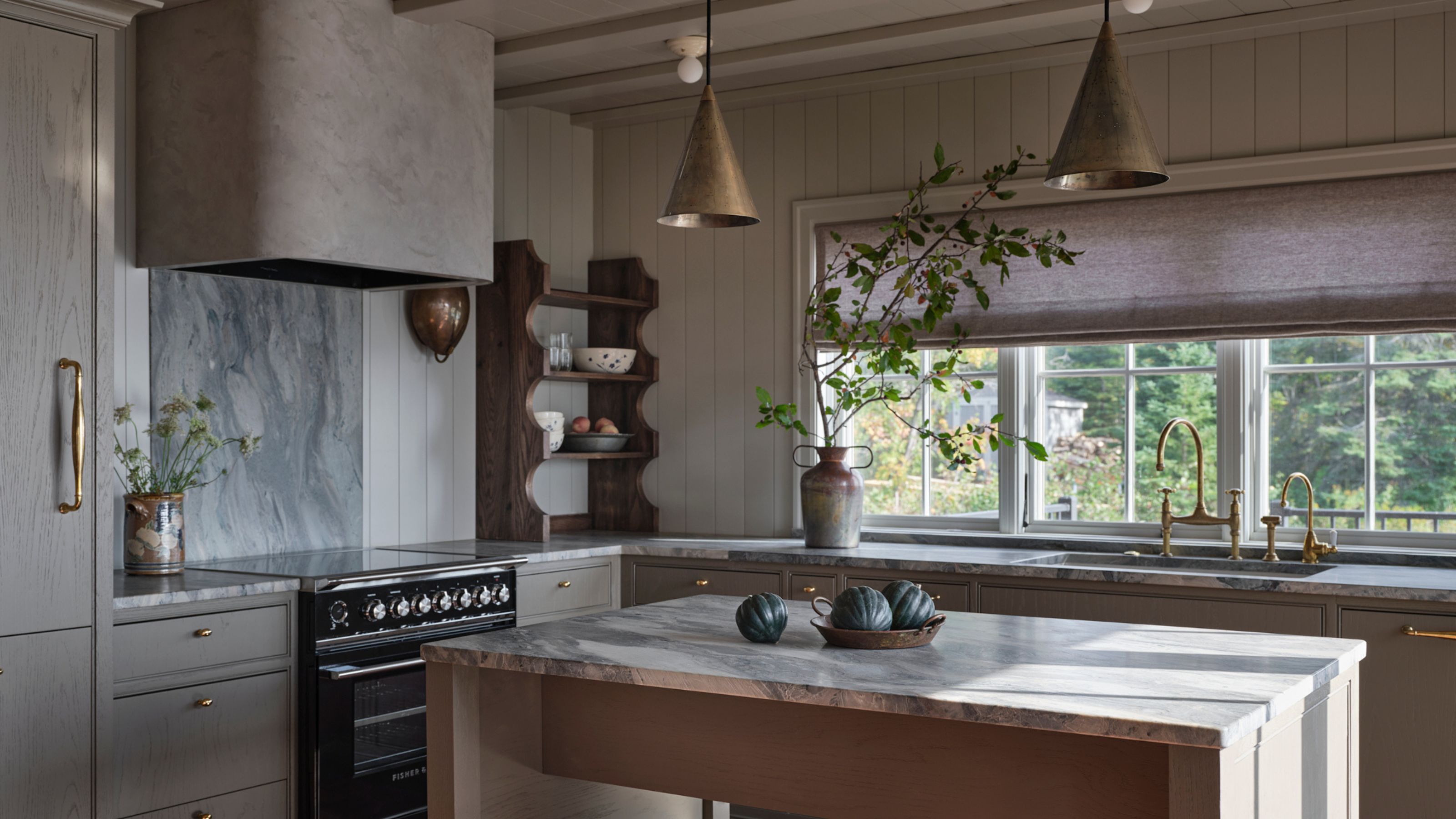 an earthy brown grey small kitchen with blue veined marble countertops and terracotta floor tiles