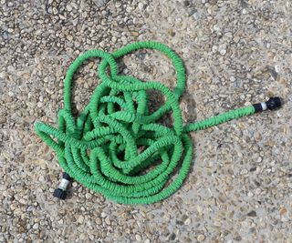 A coiled green expandable hose