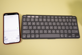 A Logitech Keys-To-Go 2 keyboard next to an iPhone 13 Mini.