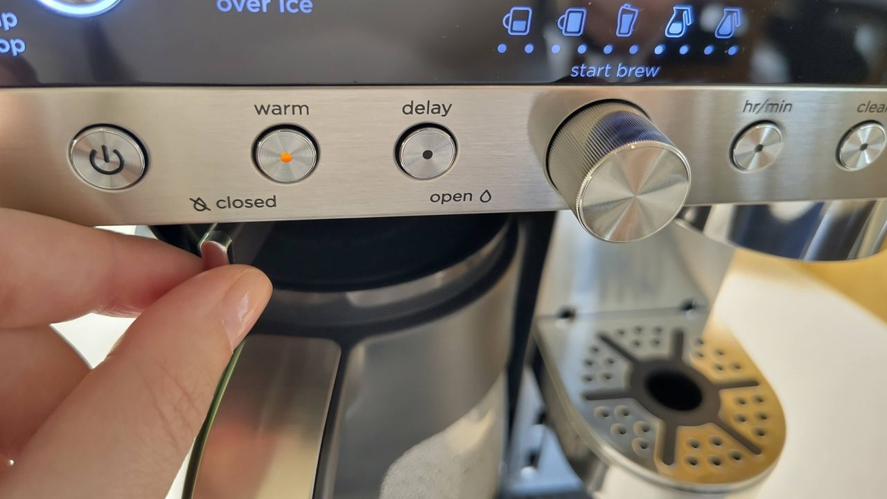 Person using Ninja Prestige Dual-Brew System drip-stop mechanism