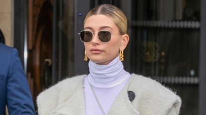 Hailey Bieber in dark sunglasses and a polo-neck jumper