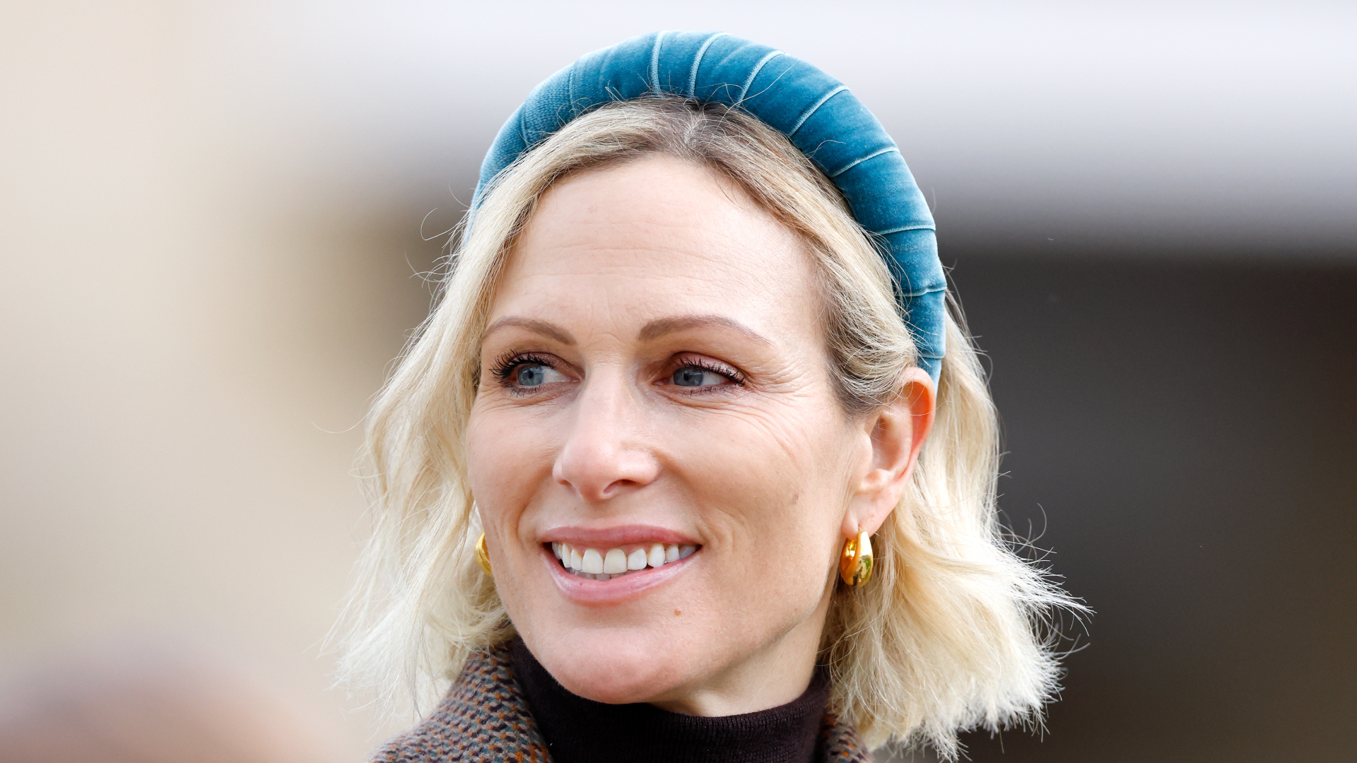 Zara Tindall wearing a blue headband and brown coat