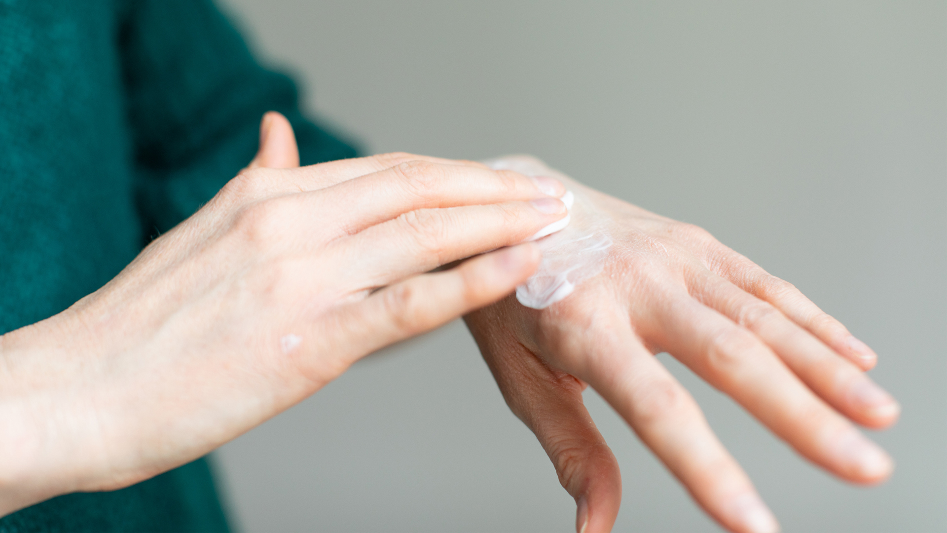 woman applying moisturizer to her hands