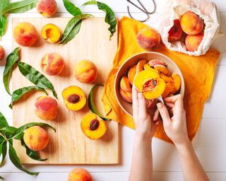 Woman's hands cutting peaches