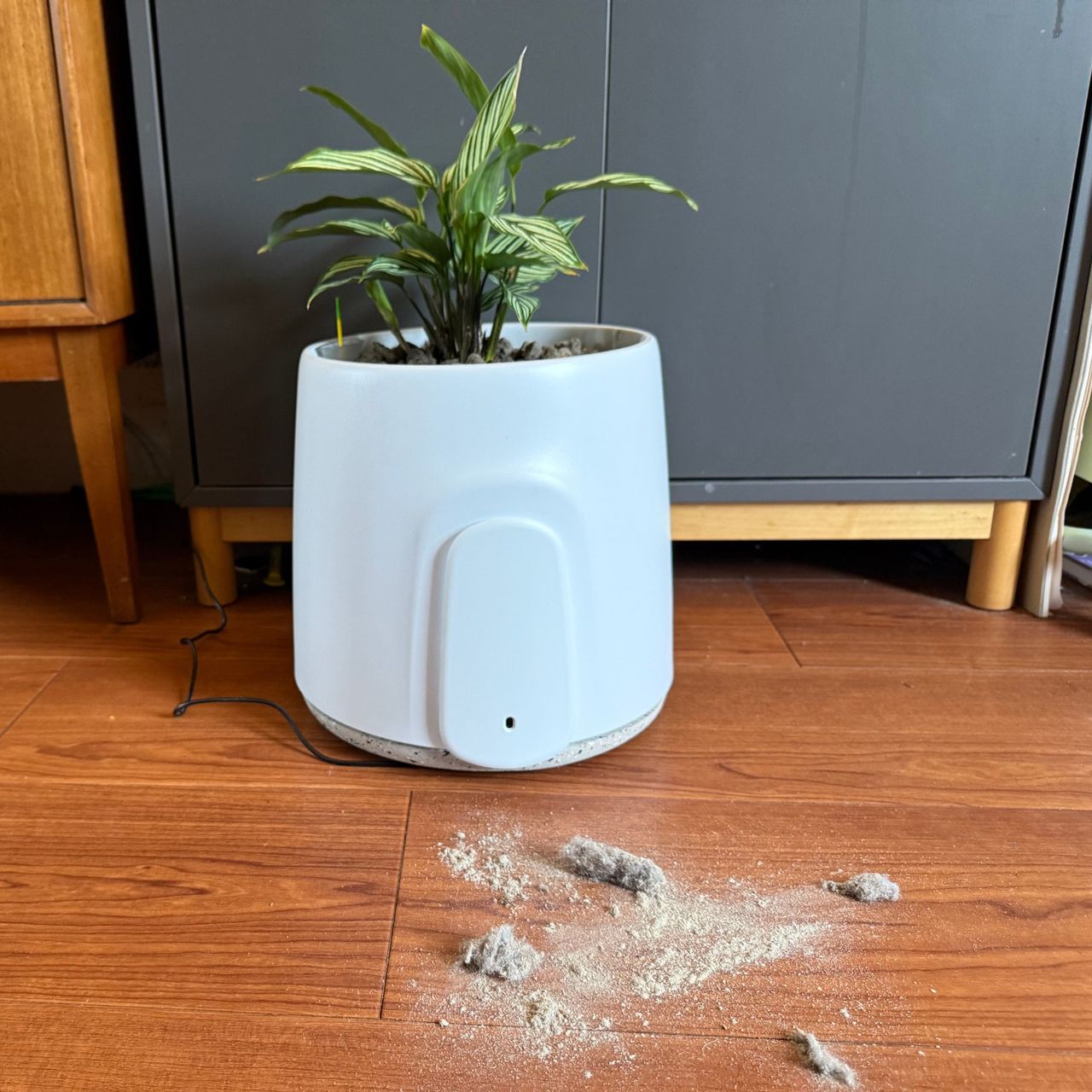 Vitesy Natede Smart air purifier on wooden floor with vacuum dust in front of it
