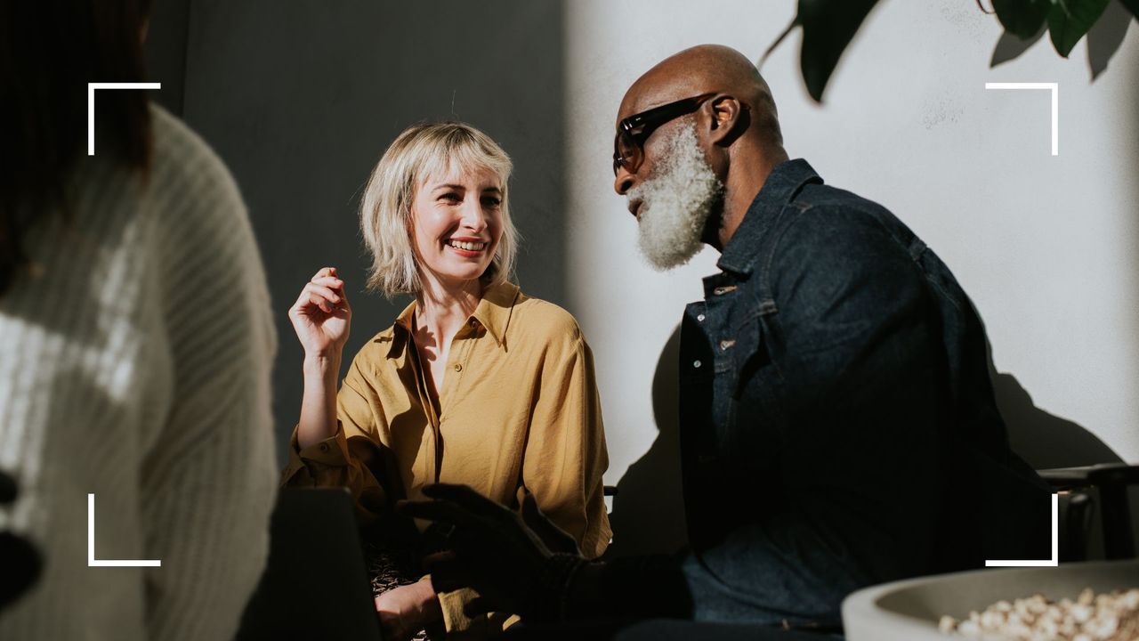 Man and woman laughing and smiling together in sunlit room with shadows cast across their faces, after learning how to overcome relationship anxiety