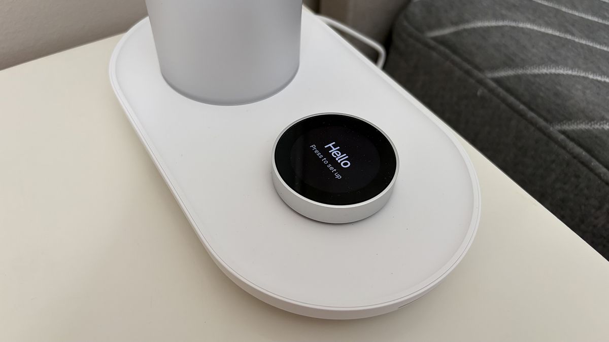A close up of the control button on the base of the Sleepal AI Lamp. The display screen on the button says 'hello'