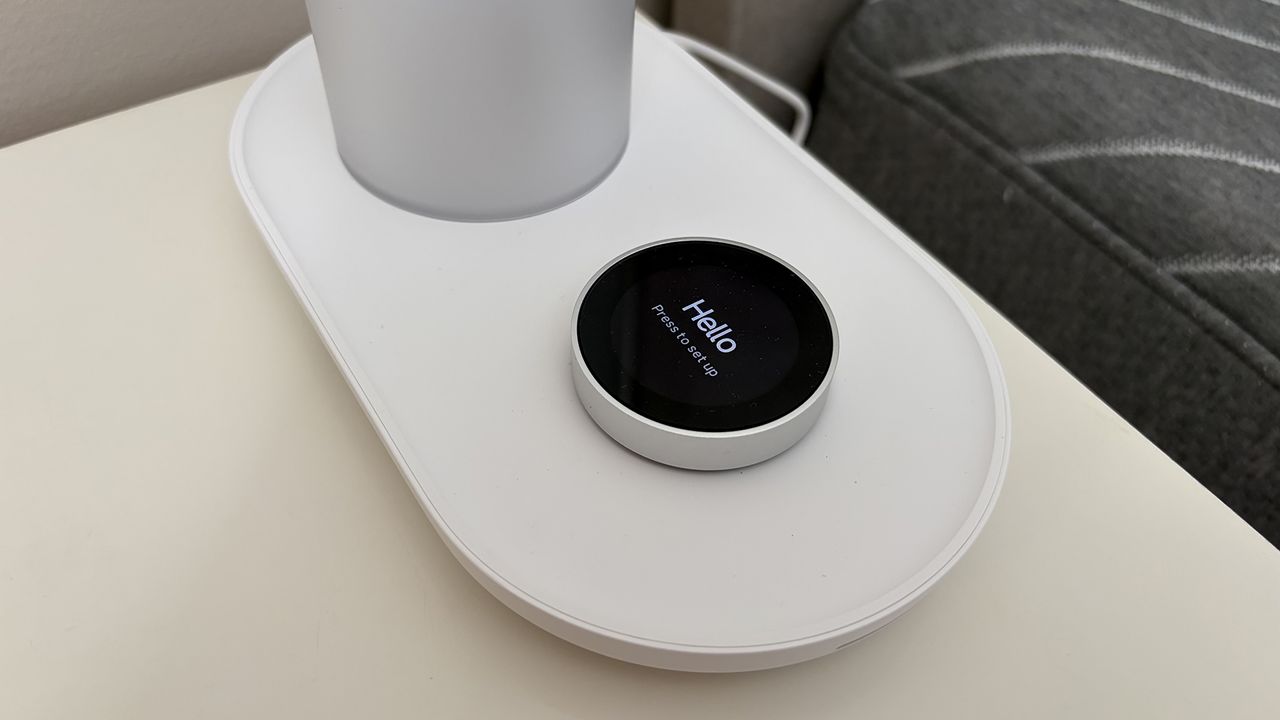 A close up of the control button on the base of the Sleepal AI Lamp. The display screen on the button says 'hello'