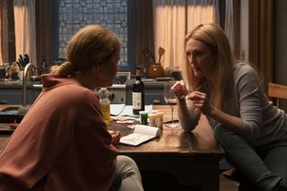 Amy Adams and Julianne Moore as Anna and Jane, sitting at Anna's kitchen table while Jane shows Anna her pendant, in The Woman In The Window