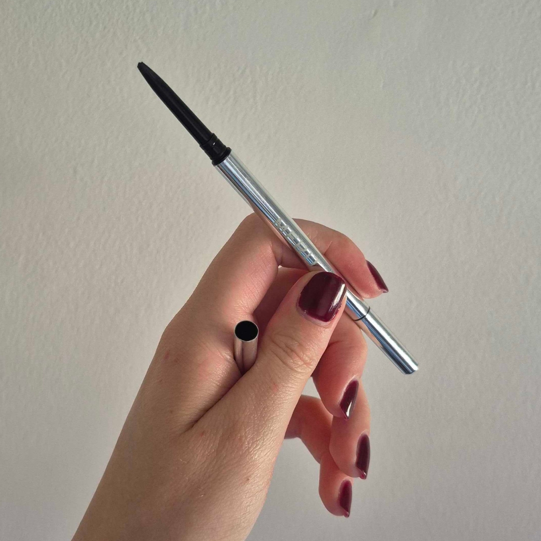 Hand holding empty Merit Beauty Brow 1990
