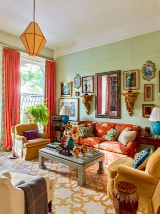 Green living room, yellow rug, lampshade and armchairs