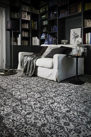 A black and white living room with a black ceiling and cornice details