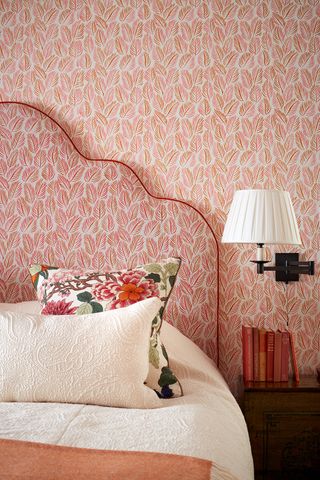 a pink bedroom with a matching headboard and wallpaper