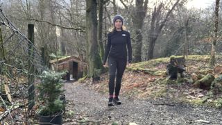 Woman hiking on forest path dressed in the Fjällräven Abisko Trekking Tights