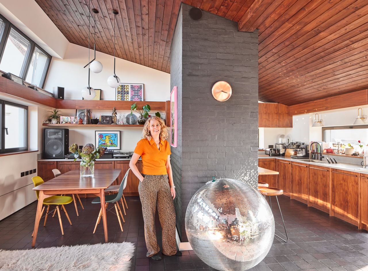A woman standing in her modernist living room with a large disco ball