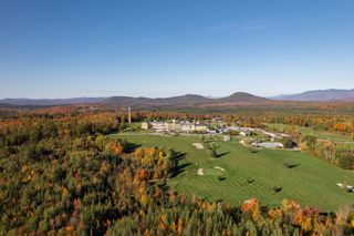 An aerial view of the Mountain View Grand Resort & Spa in New Hampshire in autumn with trees turning red and orange with the leaves