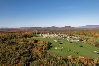 An aerial view of the Mountain View Grand Resort & Spa in New Hampshire during autumn with trees turning red and orange from the leaves