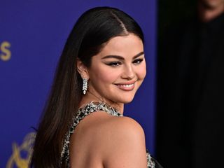 Selena Gomez looks over her shoulder wearing diamond earrings