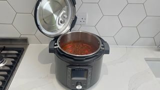 The Instant Pot Pro open with a slow-cooked chilli inside