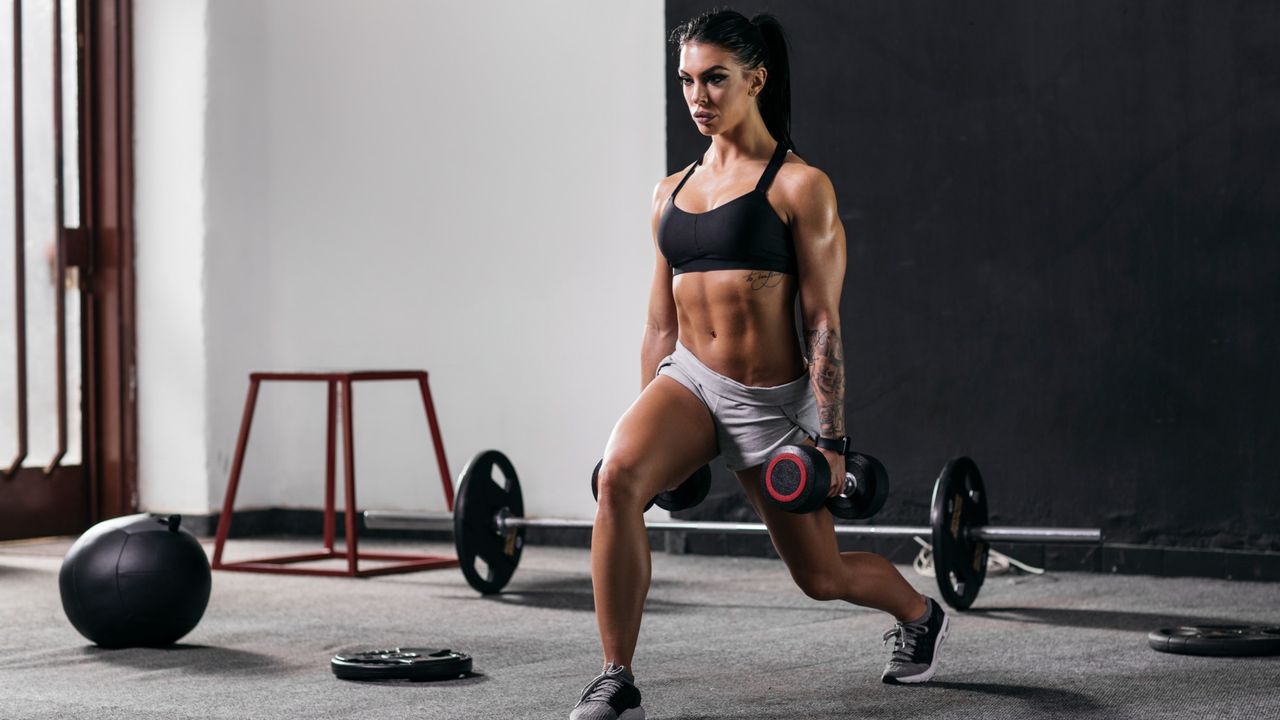 A woman performing dumbbell lunges