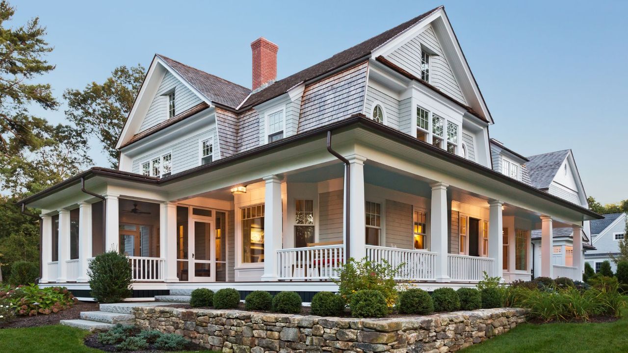 Exterior view of custom built home with exterior lighting and manicured landscaping.