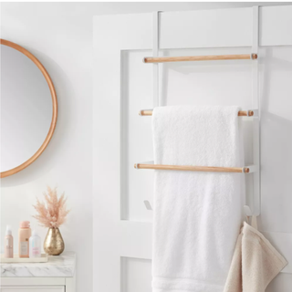 a white over the door towel rack in a white bathroom with subtle pink details
