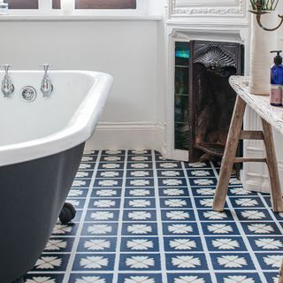 lvt bathroom flooring with blue rolltop bath and white painted fireplace