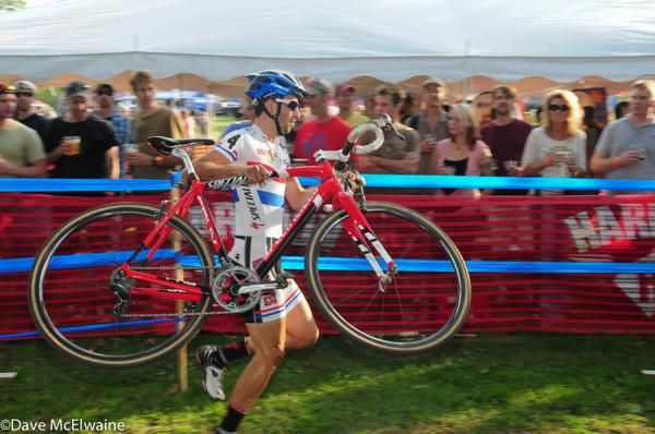 Ian Field (Hargroves Cycles) carrying his bike over the barriers