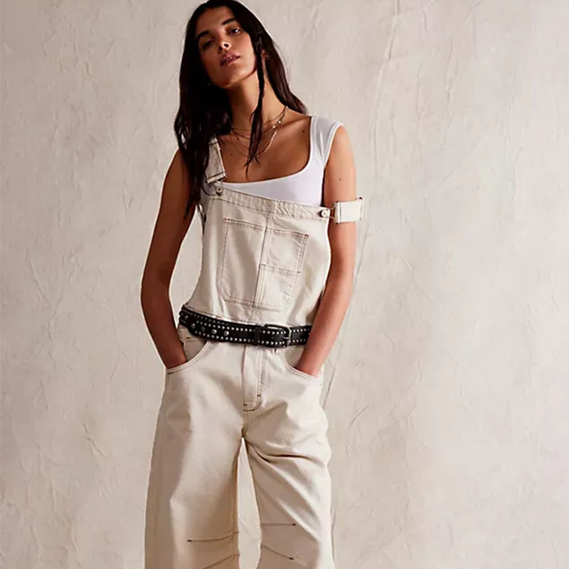 Free People model wearing cream overalls with white tank